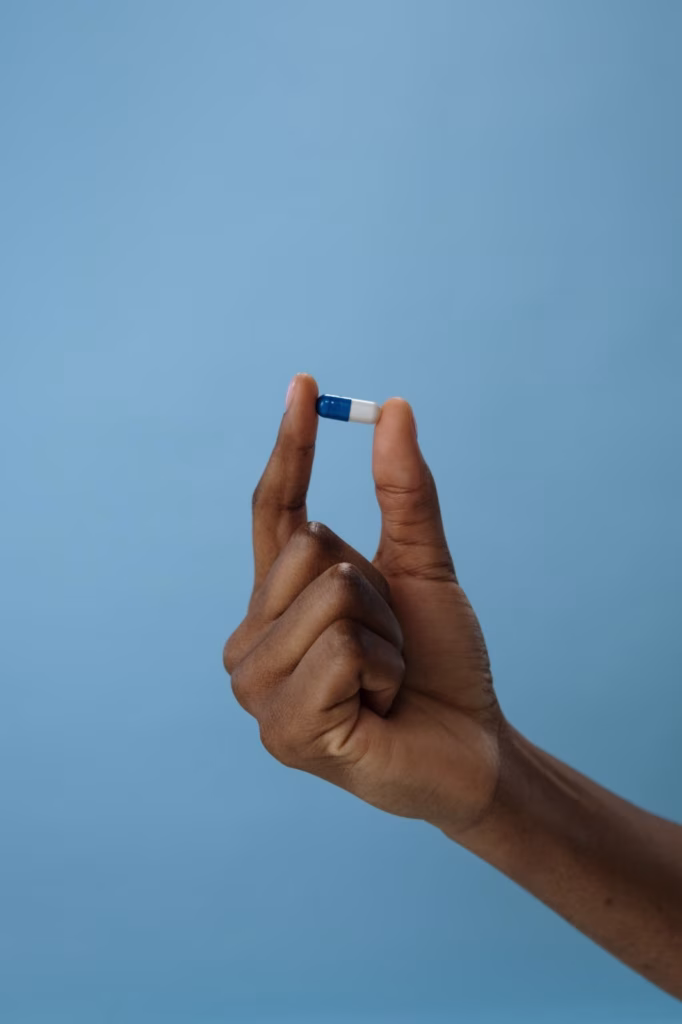 pastilla en una mano Mano sosteniendo una pastilla azul sobre fondo azul, imagen de los eurodiputados que piden a la EMA acelerar la investigación psicodélica