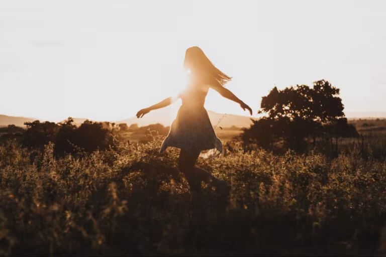 Mujer caminando por un campo a contraluz al atardecer, imagen del ensayo clínico de Small Pharma con DMT para la depresión