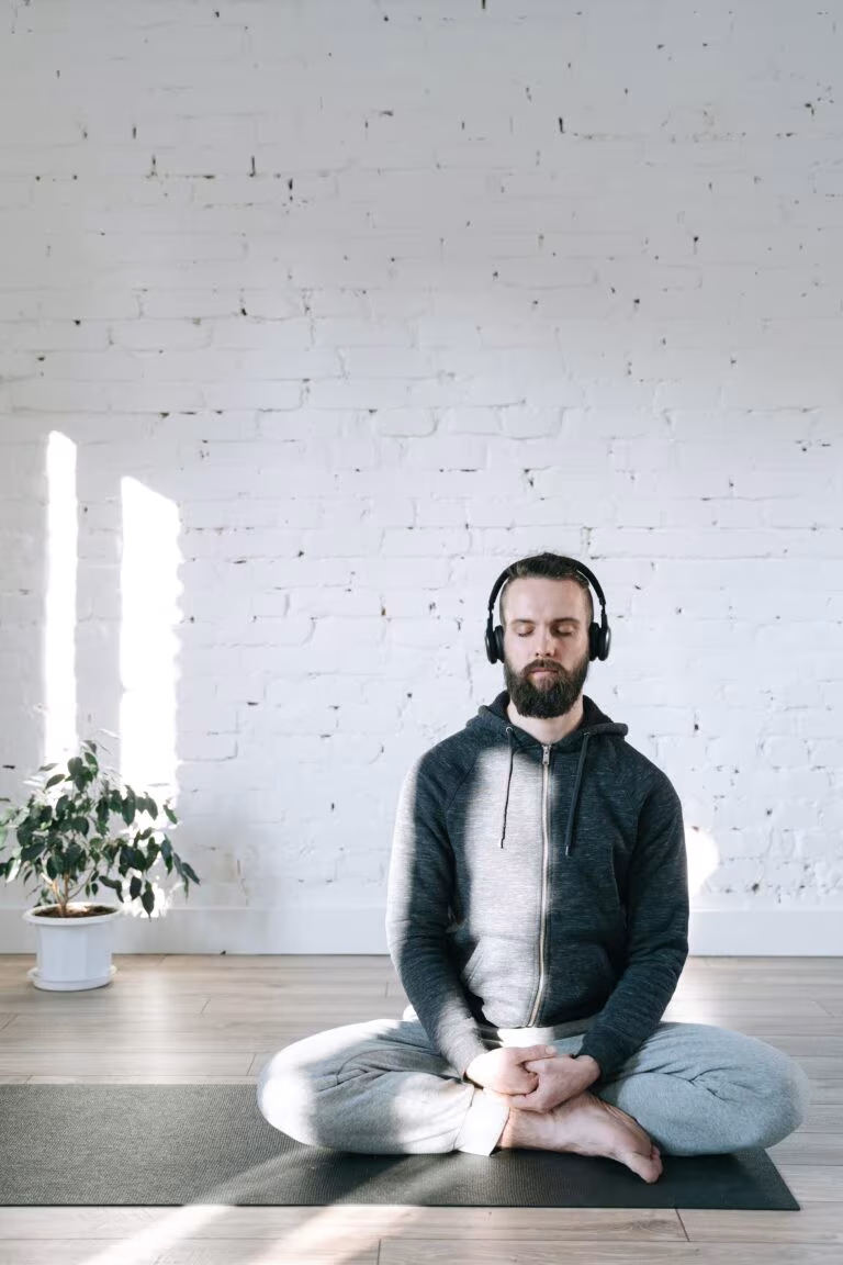 Hombre meditando con auriculares sentado en una esterilla, imagen del ensayo clínico de Small Pharma con DMT para la depresión mayor