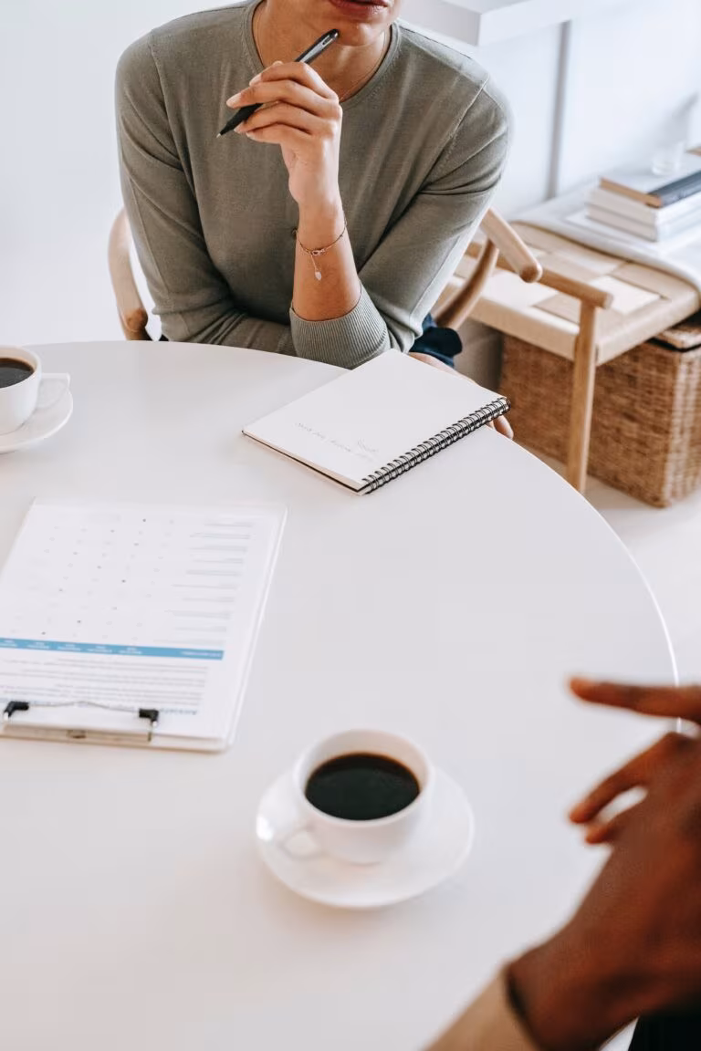 Dos personas reunidas en una mesa con documentos y café, imagen de la guía preliminar de la FDA para investigar con psicodélicos