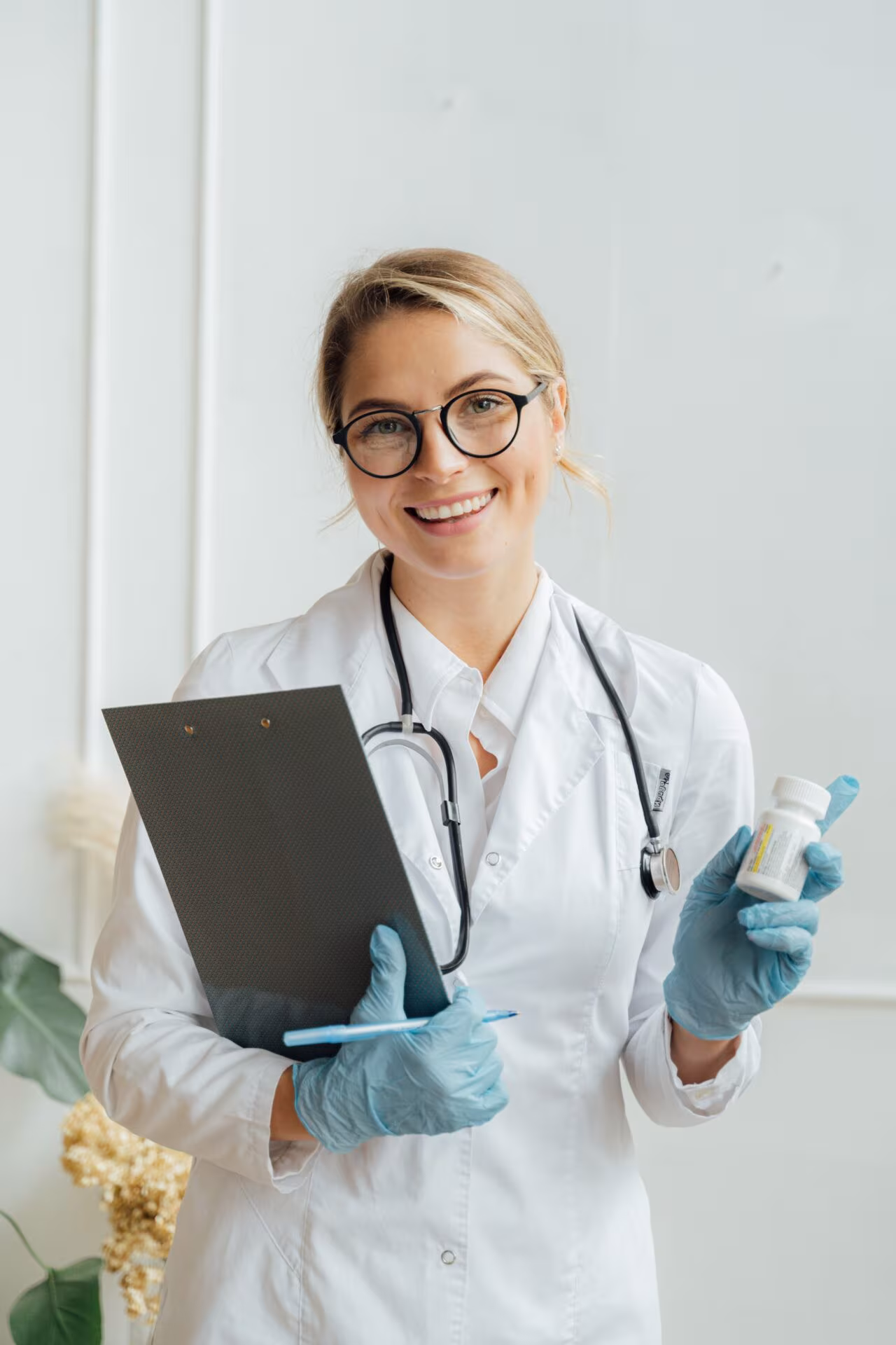 Médica sonriente con bata, estetoscopio y portapapeles, sobre la terapia asistida con psicodélicos en Australia