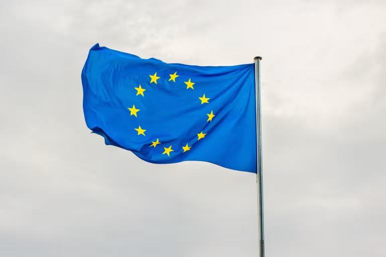 Bandera de la Unión Europea ondeando, imagen del reconocimiento del Comité Económico y Social Europeo a la terapia psicodélica
