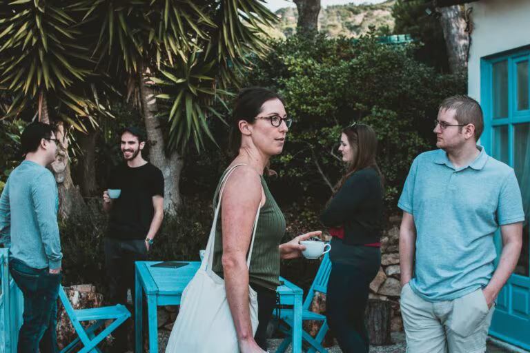 Grupo de personas conversando en un jardín, imagen de los psicodélicos y la cognición social