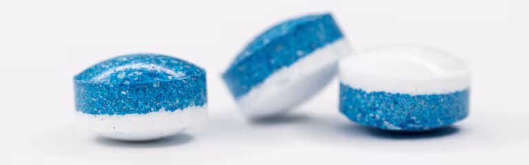 Pastillas blancas y azules sobre fondo blanco, imagen de la terapia asistida con MDMA ante su aprobación por la FDA