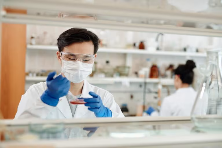Investigadores con bata y guantes trabajando en un laboratorio de neurociencia sobre el receptor 5-HT2A