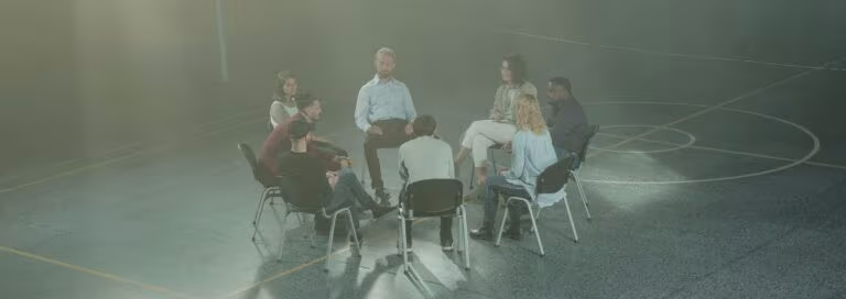 Grupo de personas sentadas en círculo en una sala, imagen de la terapia grupal asistida con psicodélicos