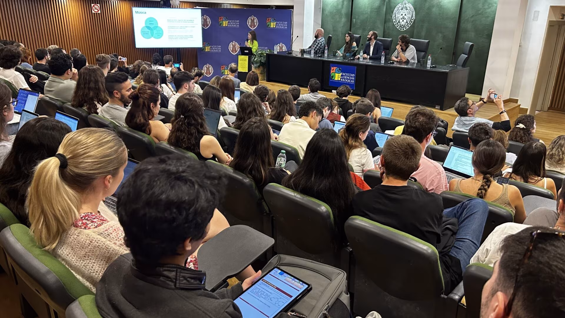 Salón de actos lleno de estudiantes en la mesa redonda de Inawe para el máster de Neurociencia de la UCM
