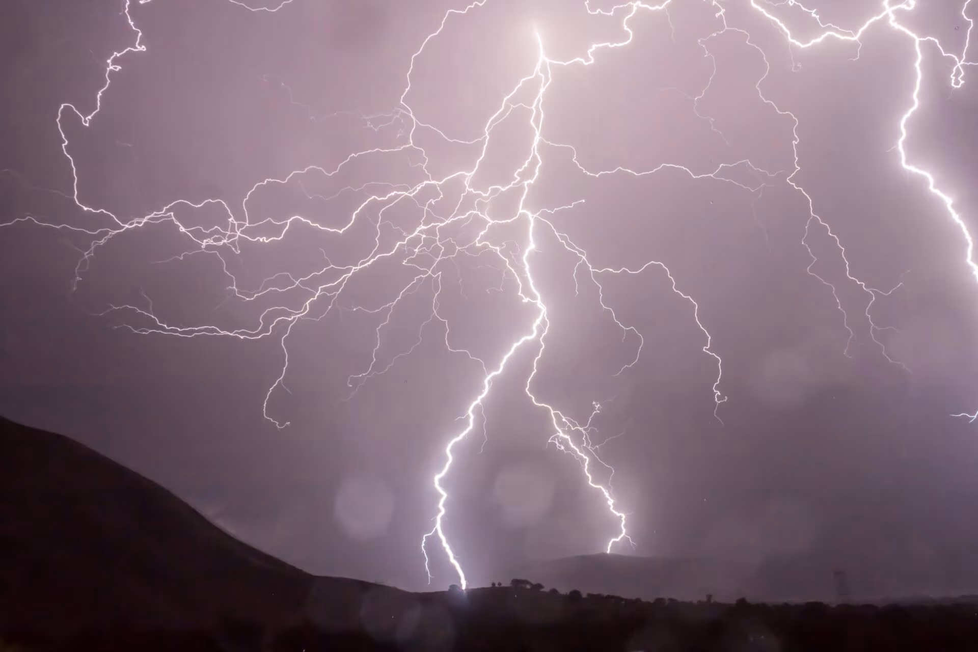 Relámpagos sobre una montaña en un cielo nocturno, imagen de las estrategias para afrontar malas experiencias con psicodélicos
