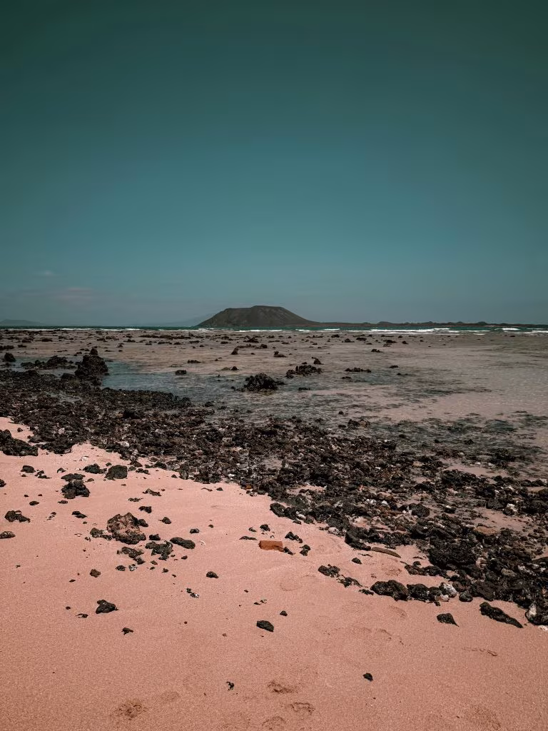 Playa de Fuerteventura con un islote al fondo, imagen de la conferencia internacional sobre psicodélicos Fuertedélica III