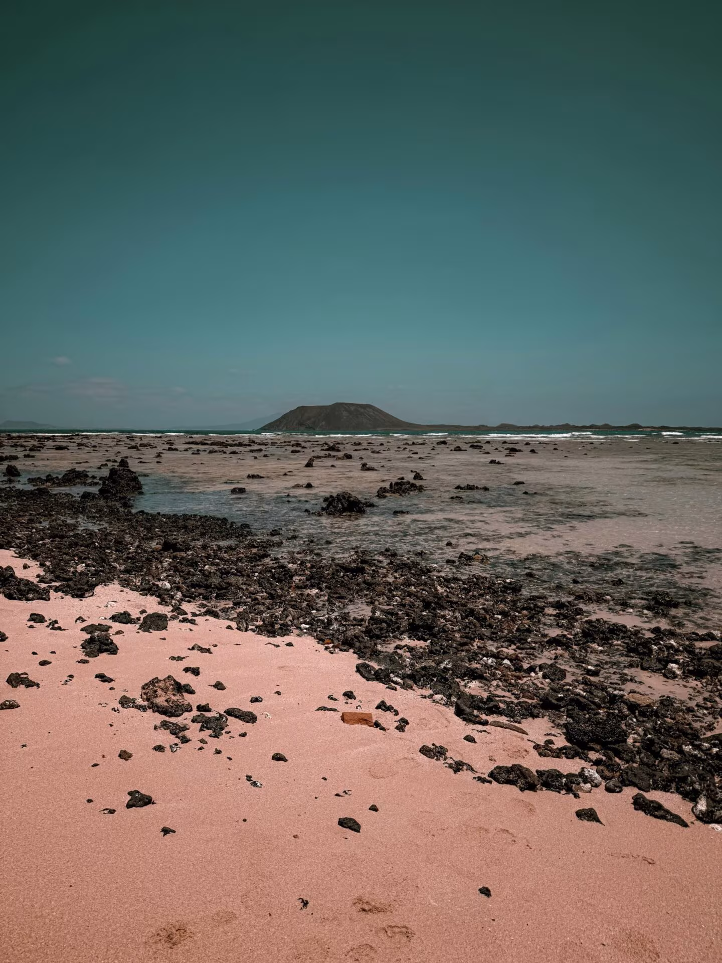 Playa de Fuerteventura con un islote al fondo, imagen de la conferencia internacional sobre psicodélicos Fuertedélica III
