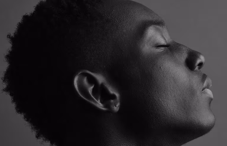 Retrato en blanco y negro de un hombre con los ojos cerrados, imagen del resplandor posterior tras el consumo de MDMA
