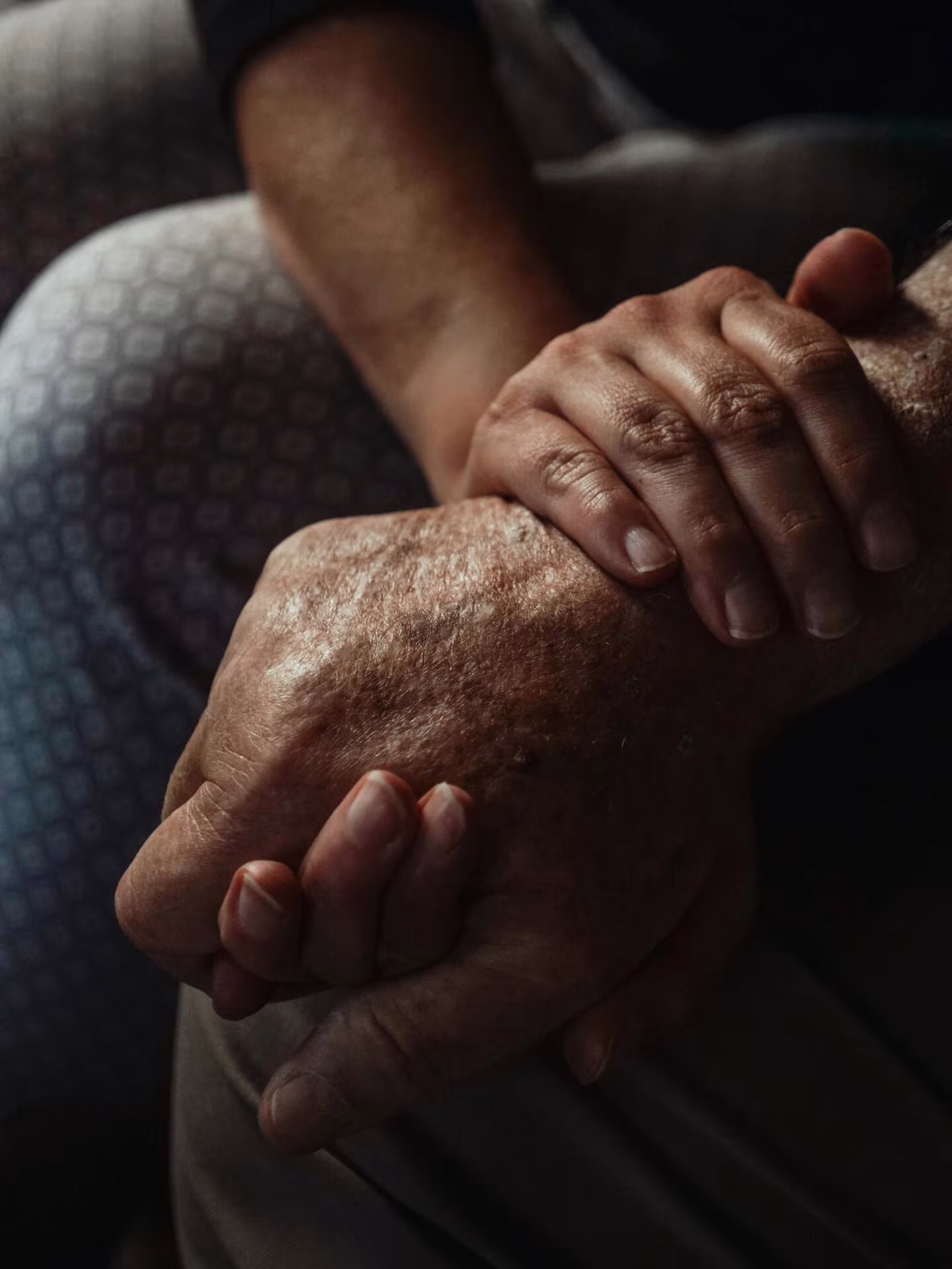 Manos entrelazadas de una persona mayor, imagen del estudio sobre psilocibina y estado de ánimo en la enfermedad de Parkinson