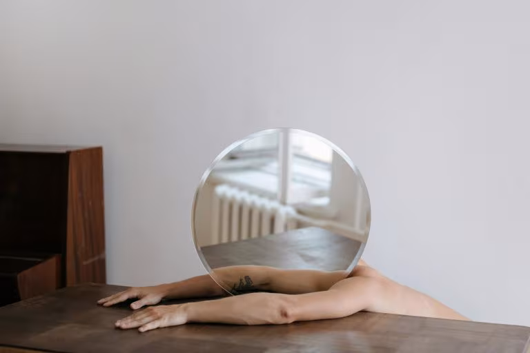 Brazos sobre una mesa sosteniendo una esfera de cristal, imagen de la formulación inspirada en la ayahuasca y la cognición social