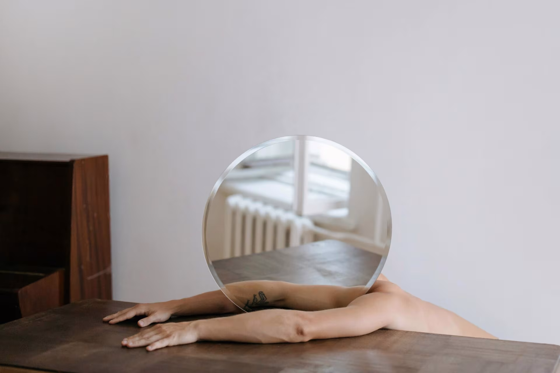 Brazos sobre una mesa sosteniendo una esfera de cristal, imagen de la formulación inspirada en la ayahuasca y la cognición social