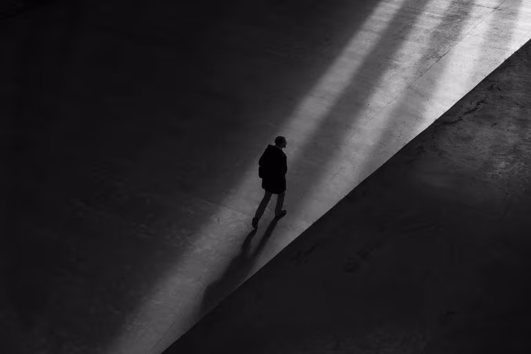 Persona caminando sola por una rampa en blanco y negro, imagen de los riesgos epistémicos de los psicodélicos sobre las creencias