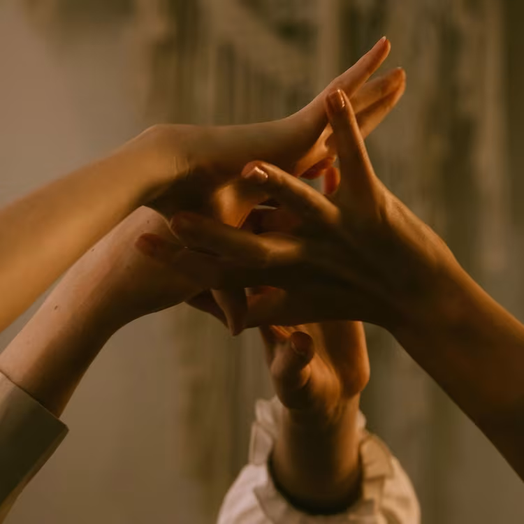 Manos entrelazándose a contraluz, imagen de lo que Fundación Inawe ofrece a sus voluntarios